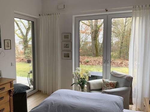 Schlafzimmer mit Blick in den Garten und Zugang zur Terrasse - 
