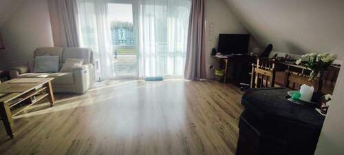 Wohnzimmer mit Terrassentür zum Balkon - 