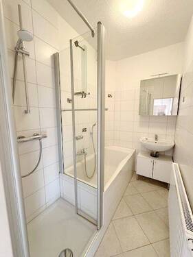 Hell gefliestes Bad mit Wanne und Dusche - 