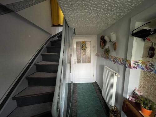 Flur mit massiver Holztreppe in das Obergeschoss - 