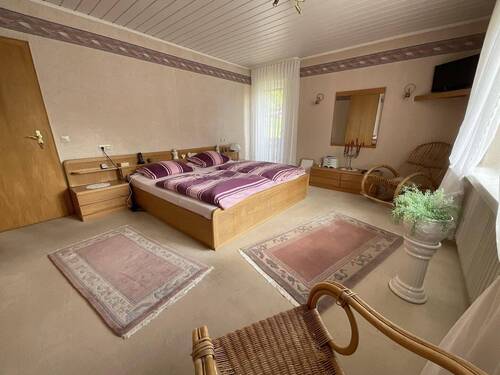 Schlafzimmer im Obergeschoss mit Zugang zum Balkon - 