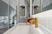 hochwertige Amaturen von Hansgrohe und Regendusche im Hintergrund - 