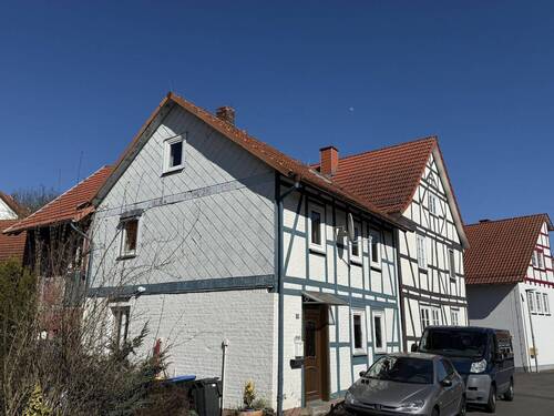 Schrägansicht Haus mit Nachbarschaft - 4 Zimmer Einfamilienhaus zum Kaufen in Nentershausen / Süß