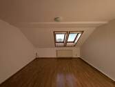 Zimmer 1 - zentrumsnahe Dachgeschosswohnung mit praktischem Schnitt.