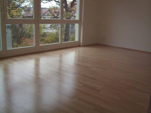 Wohnzimmer mit großem Fenster zum Garten - Etagenwohnung in Leipzig zum Kaufen