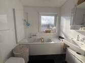 Modernes Badezimmer mit Wanne und Fenster - 