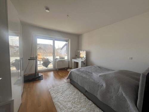 Helles Schlafzimmer mit Balkonzugang und hochwertigen Holzböden - 