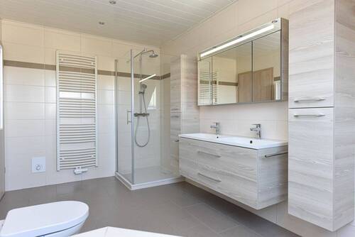 modernes Vollbad mit Fußbodenheizung, Doppelwaschtisch, Dusche und Eckbadewanne - 