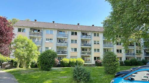 Rückseite des Hauses mit Balkonen und Grünfläche - 