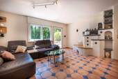 Wohnzimmer mit Kachelofen und Zugang zur Terrasse - 