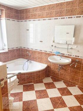 Wannenbadezimmer mit Fenster, Dusche und behindertengerechter Toilette - 