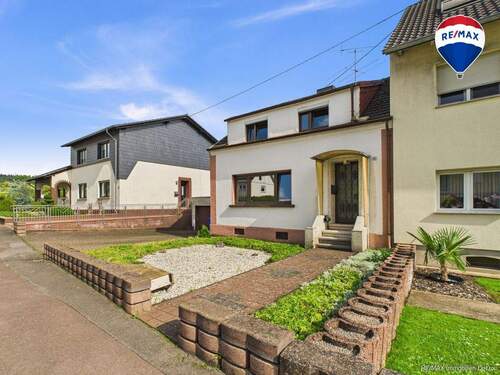 RE/MAX Immobilien DeLux Einfamilienhaus Nalbach Frontansicht - Charmantes Einfamilienhaus mit großem Garten und Waldblick - Sanierungsobjekt mit Potenzial!