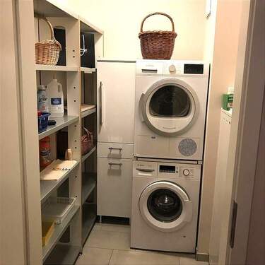 Wirtschaftsraum mit Waschmachine, Waschtrockner, Regalen - 