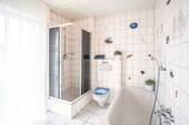 Das Bad ist mit einer Wanne und einer Dusche ausgestattet. - 