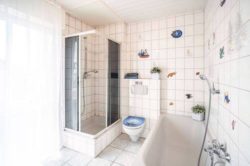 Das Bad ist mit einer Wanne und einer Dusche ausgestattet. - 