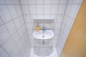 Das separate Gäste-WC ist ebenfalls hell gefliest. - 
