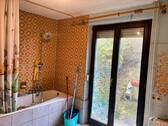 Badezimmer mit Badewanne und Gartenzugang - 