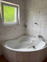Badezimmer mit Fenster und Wanne - 
