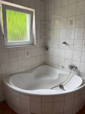 Badezimmer mit Fenster und Wanne - 