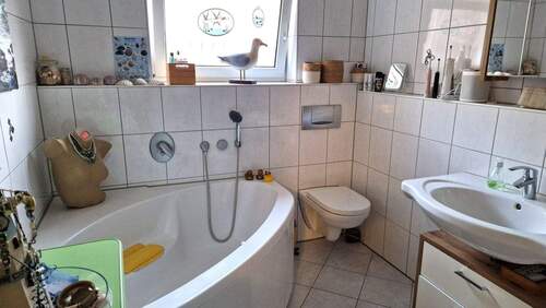 Bad mit Eckbadewanne, Dusche und Fenster - 
