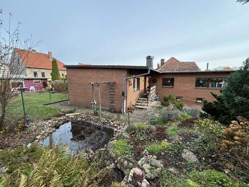 Blick von der Seiter über den Teich zum Haus - Kleines Einfamilienhaus mit Garten in zentraler Lage in Schöningen