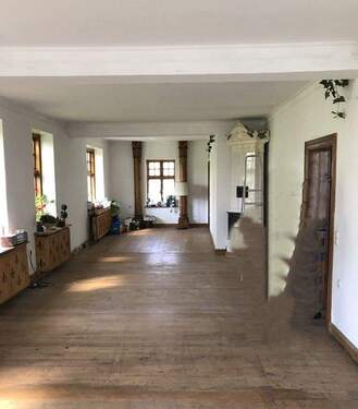 Großer Wohnraum im Haupthaus mit schönem Kachelofen - 