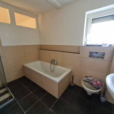 Badezimmer mit Wanne und Fenster - 