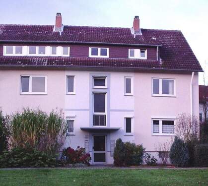 Gebäude Vorderseite des mehrstöckigen Wohnhauses umgeben von Grünanlagen mit Bäumen und Sträuchern - 