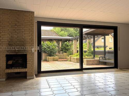 Wohnbereich mit Kamin und Terrassenzugang - 