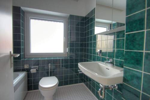Badezimmer mit Badewanne und Fenster - 