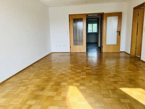 Wohnzimmer mit Parkett und zwei Türen zum Flur - 