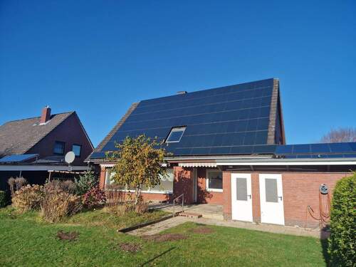 Blick auf die Photovoltaikpaneele und Zugangstüren Keller / Garage - 