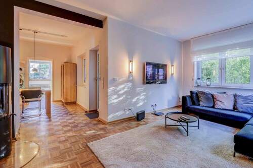 Wohnzimmer mit Zugang Esszimmer - Renovierte Erdgeschosswohnung mit Garten & TG-Stellplatz - Vermietetes Altbaujuwel in zentraler Lage