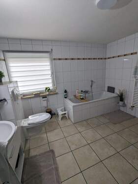 Badezimmer mit Wanne und Dusche - Tolle Wohnung mit sonniger Dachterrasse, Balkon und Doppelgarage in Allendorf gelegen