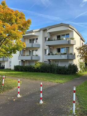Gebäude Rückseite des mehrstöckigen Wohnhauses mit Blick in die Grünanlage mit Sträuchern - Tolle 3-Zimmerwohnung kann angemietet werden!
