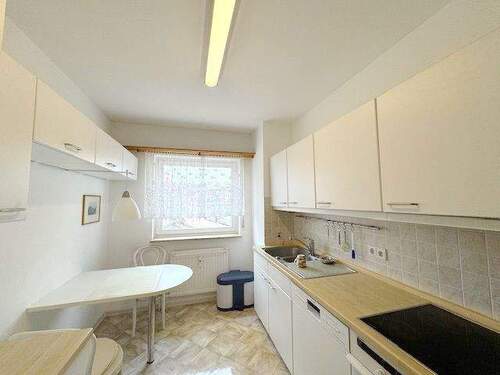 Küche mit Einbauküche und kleinem Sitzplatz - 