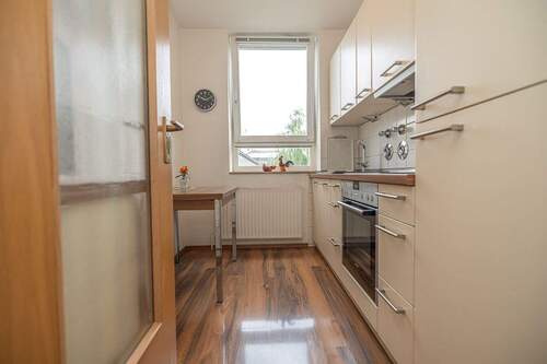 Schlichte Fronten vergrößern die schmale Küche optisch - 