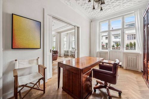 Das Arbeitszimmer mit Sicht ins Wohnzimmer und Zutritt auf den Balkon - 