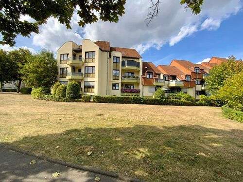 Rückseite der Gebäude im Käthe-Kollwitz-Weg mit Balkonen und großer Wiese im Vordergrund - 3 Zimmer Etagenwohnung zur Miete in Baunatal