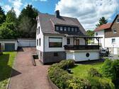 Frontansicht mit Garagen - Geräumiges Einfamilienhaus mit Einliegerwohnung in ruhiger Lage mit Fernblick über Benterode