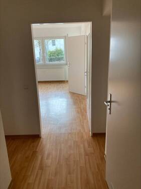 Beispielbild: Flur mit PVC-Bodenbelag in Holzoptik mit Blick ins Wohnzimmer - 1 Zimmer Etagenwohnung in Friedrichsdorf