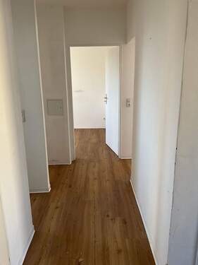 Blick in den Flur. Brauner Vinylboden. Decken und Wände weiß gestrichen. Türen weiß lackiert. - 2 Zimmer Etagenwohnung in Ginsheim-Gustavsburg
