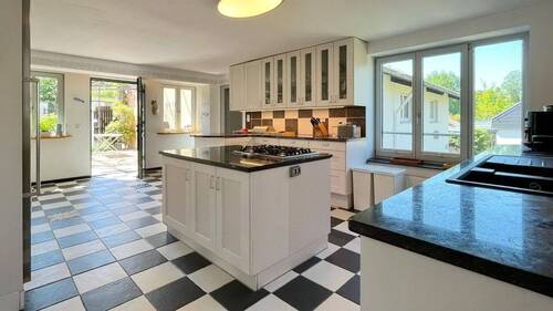 Die zeitlose Küche bietet viel Stauraum und ist mit Gas- und Elektroherd ausgestattet - 