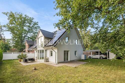Ansicht vom Garten mit PV-Anlage und Carport - 