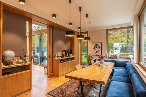 Geschmackvoll gestalteter Essbereich mit großem Holztisch und Zugang zum Wohnbereich - 