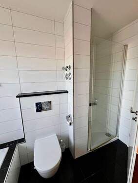 Modernes Badezimmer mit ebenerdiger Dusche und hochwertiger Ausstattung - 