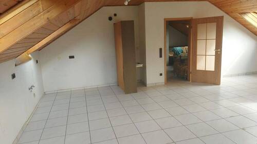 Wohnzimmer mit opt. Möbel - Großzügige 2-Zimmer Dachgeschosswohnung im Grünen