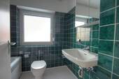 Badezimmer mit Badewanne und Fenster - 