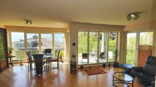 Wohn-Ess-Zimmer mit ringsum bodentiefen Fenstern - 