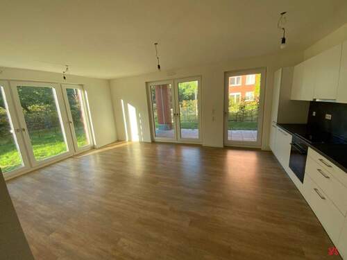 Wohnzimmer mit weißen Wänden und holzfarbenen Vinylboden - 